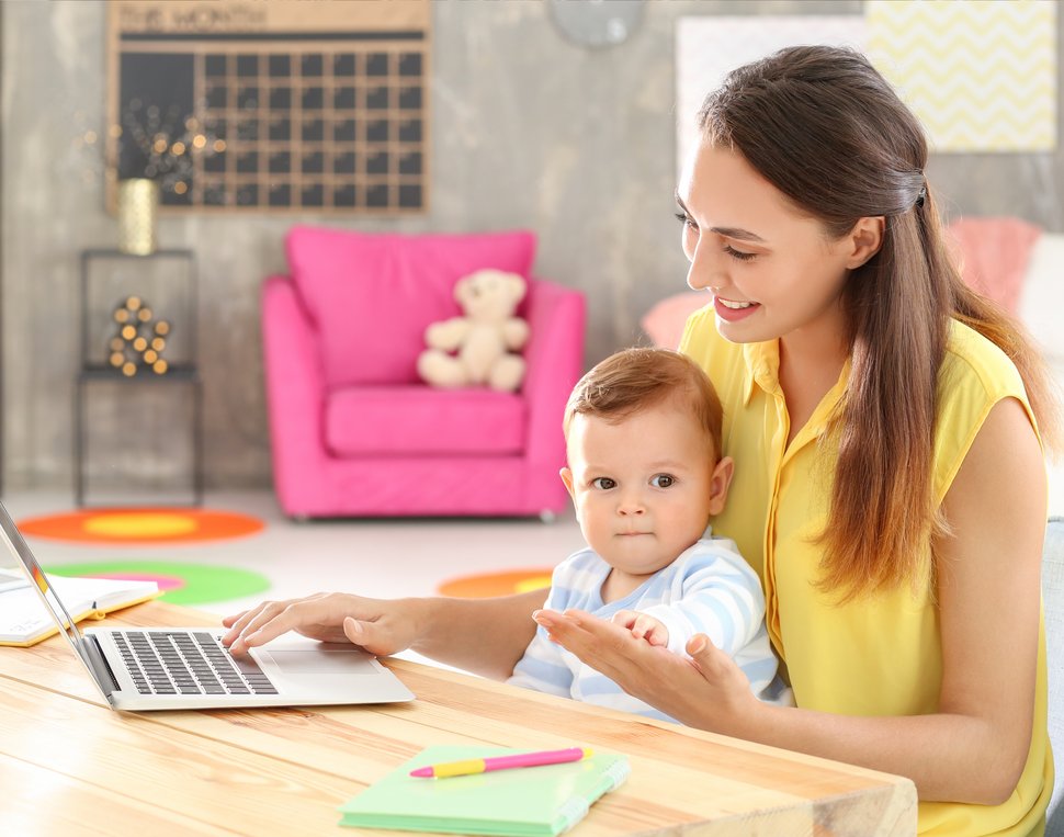Frau mit Kind vor Laptop