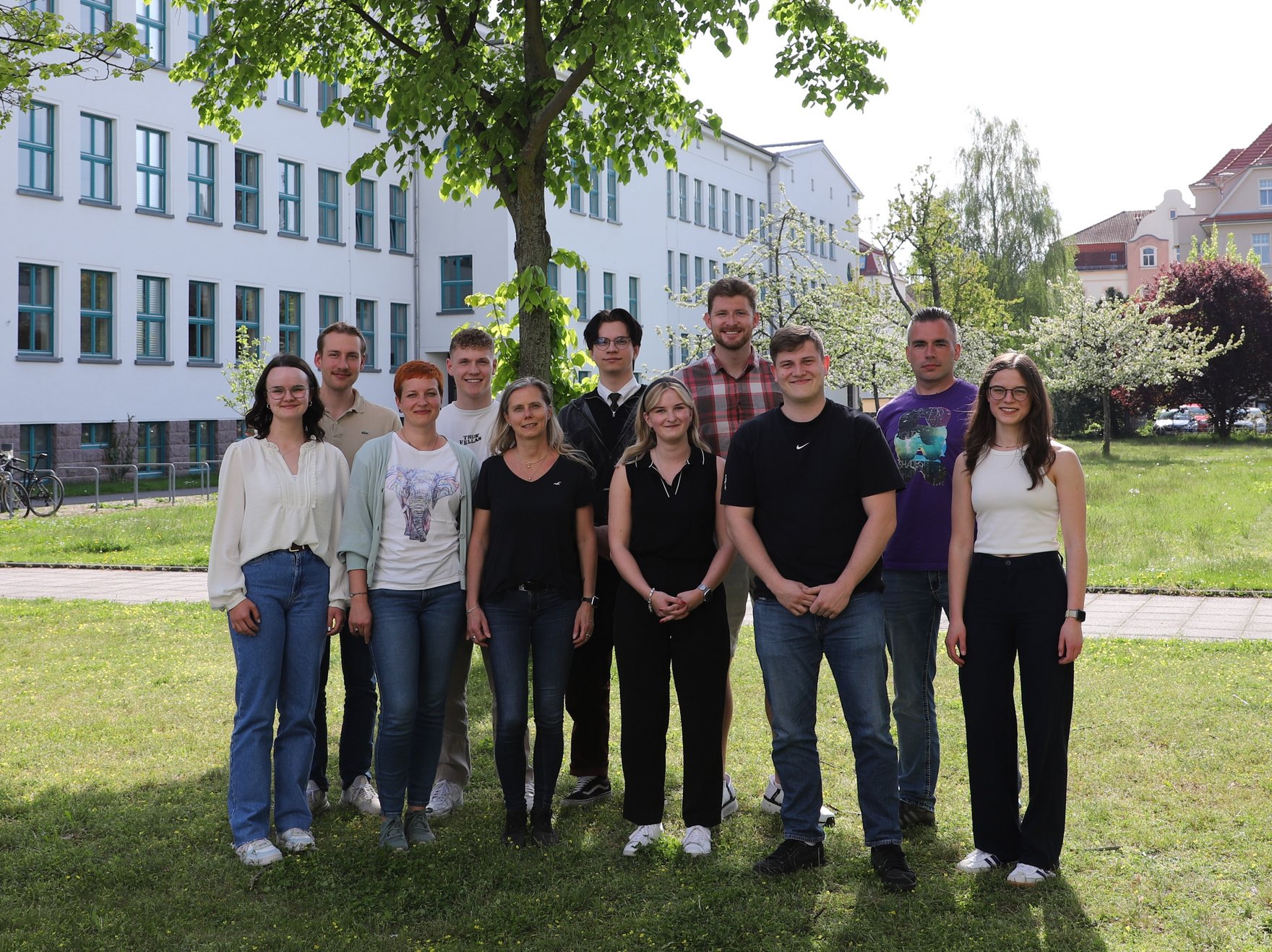 Auf dem Foto sind alle Mitglieder des Studierendenrates der HSF Meißen auf einer Wiese vor Haus 1 des Campus zu sehen.