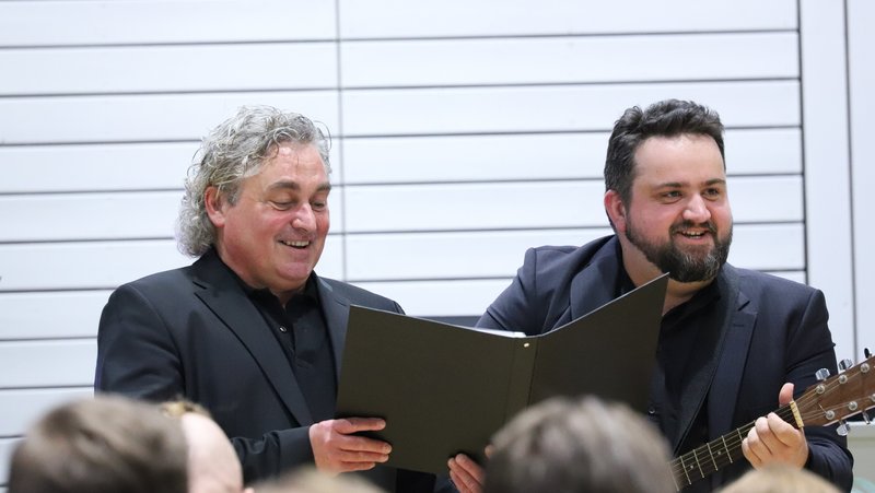 Zwei Chormitglieder beim Singen und Musizieren