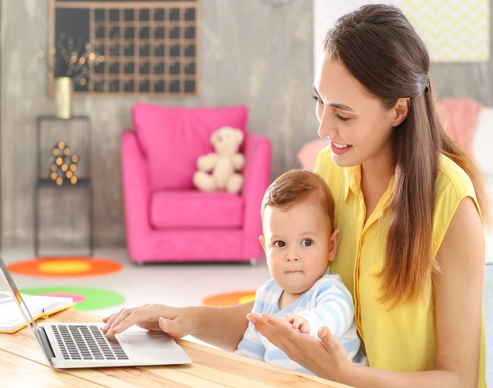 Frau mit Kind vor Laptop
