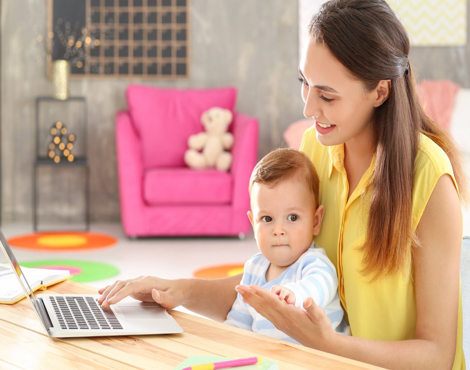 Frau mit Kind vor Laptop